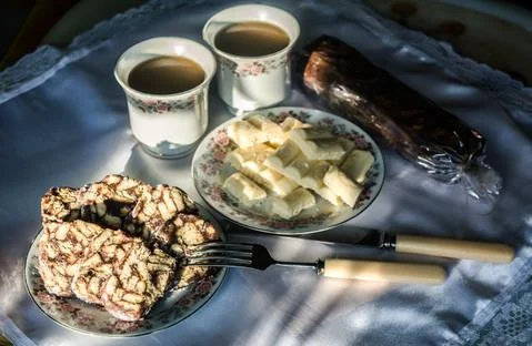Two plates with sweets (chocolate and cookies) and two cups Stock Photos