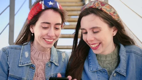 Two pleasant millennials Hispanic sisters use application on smart phone device Stock Footage 106193857