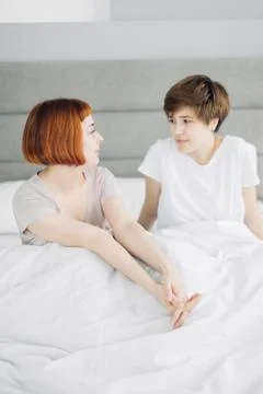 Two pleasant sisters sharing secrets in the bedroom Stock Photos