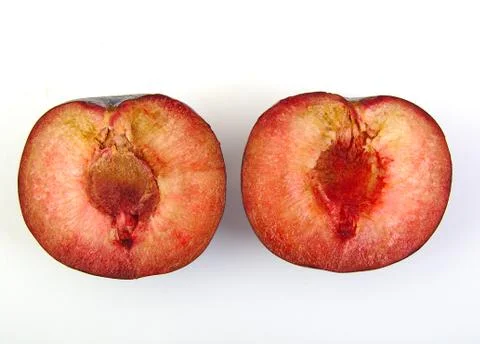 Two plum halves on white background Stock Photos