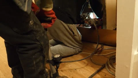 Two plumbers working on sewage pipe patch repair, pumping flexible packer. 動画素材 303210125