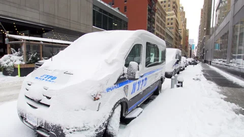 Two police mini vans covered with snow after heavy snow fall. Street of NYC Stock Footage 170400527