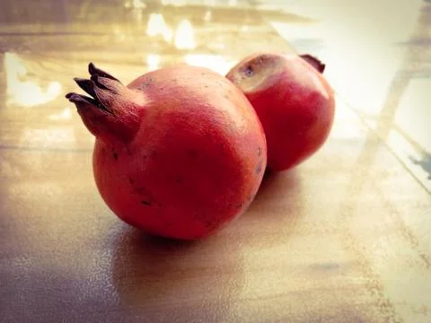 Two pomegranates placed facing opposite. Stock Photos