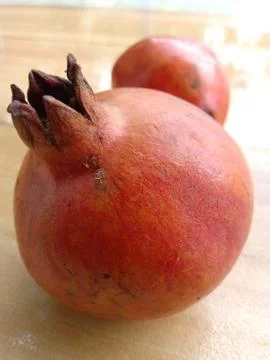 Two pomegranates placed facing opposite. Stock Photos
