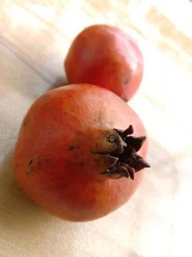 Two pomegranates placed in floor. Stock Photos