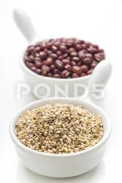 Two porcelain bowls with sesame seeds and azuki isolated Stock Photos