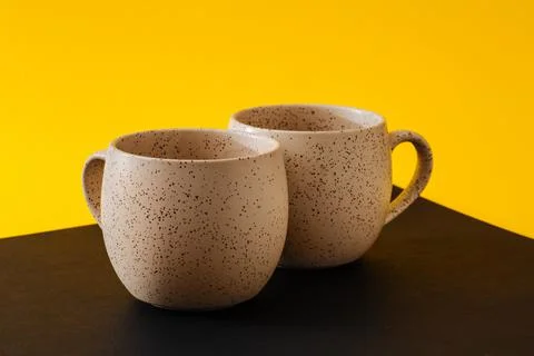 Two porcelain empty cups on a black and yellow background, copy space Foto stock