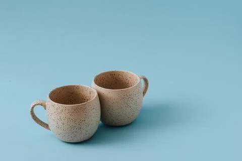 Two porcelain empty cups on a blue background, copy space. Stock Photos