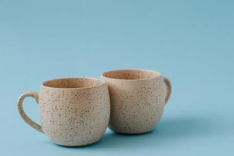 Two porcelain empty cups on a blue background, copy space. Stock Photos