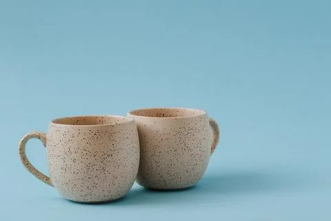 Two porcelain empty cups on a blue background, copy space. Stock Photos