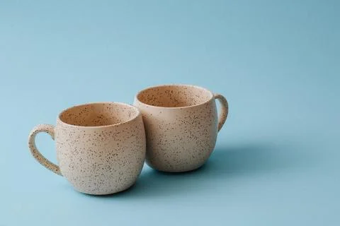 Two porcelain empty cups on a blue background, copy space. Stock Photos