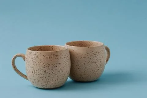 Two porcelain empty cups on a blue background, copy space. Stock Photos