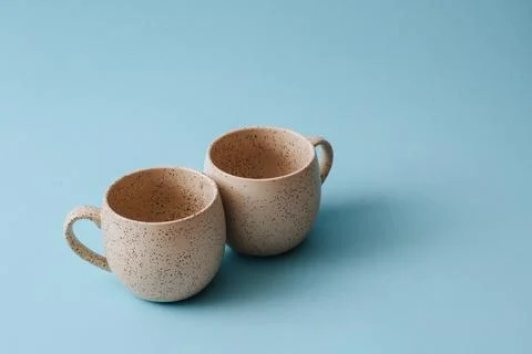 Two porcelain empty cups on a blue background, copy space. Stock-Fotos