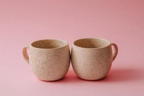 Two porcelain empty cups on a pink background, copy space. Foto stock