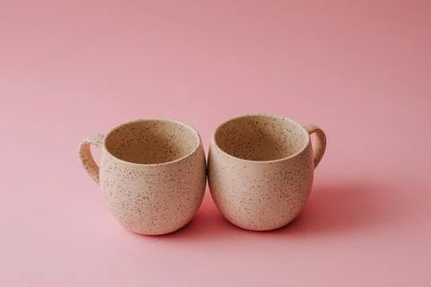 Two porcelain empty cups on a pink background, copy space. Stock Photos