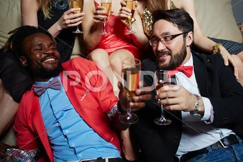 Two posh guys cheering with champagne at booze Stock Photos