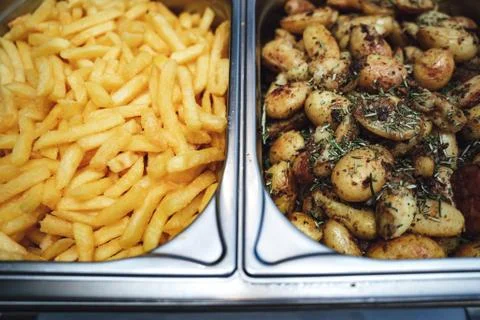 Two potato side dishes in separate hotel pans. French fries and baked potatoes Stock Photos