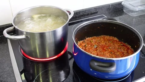 Two pots preparing macaroni bolognese Stock Footage 296488767