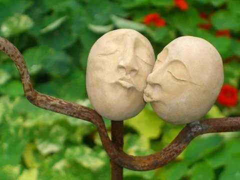 Two pottery heads cuddle close together put as decoration in a garden 写真素材