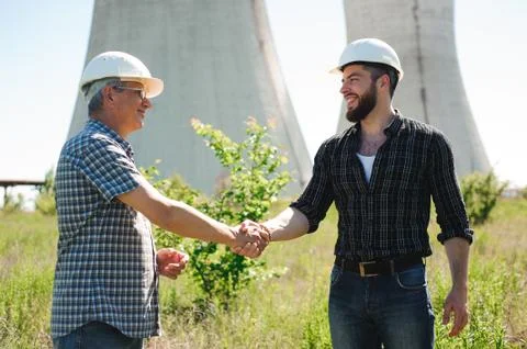 Two power line tower workers with handshaking Stock Photos