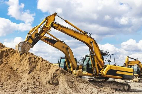 Two powerful excavators work at the same time on a construction site 库存照片