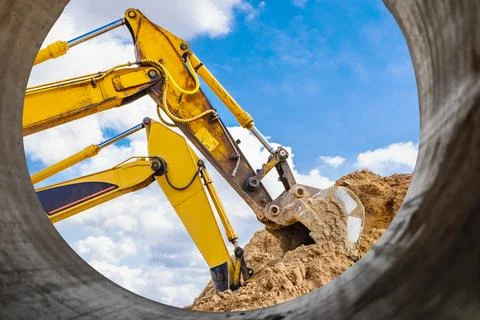 Two powerful excavators work at the same time on a construction site, sunny.. Stock Photos