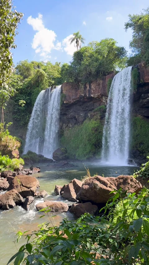 Two powerful waterfalls cascading from a high rocky cliff Stockbeeldmateriaal 337061135