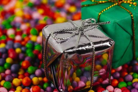 Two present boxes, silver and green gift box among polystyrene colorful balls Stock Photos