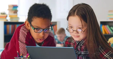 Two preteen diverse students using laptop in classroom 스톡 동영상 153419266