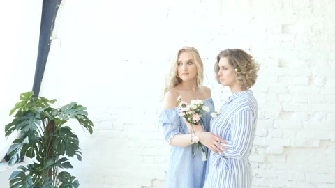 Two pretty blonde girls posing for photos, girls in casual clothes  動画素材 88960772