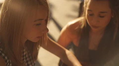 Two pretty girlfriends laughing while sitting in a bar outdoors Stock Footage 66261643