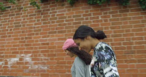 Two Pretty Mixed Race Young Girl Twins Walking Together Along a Street. Stock Footage 94550892