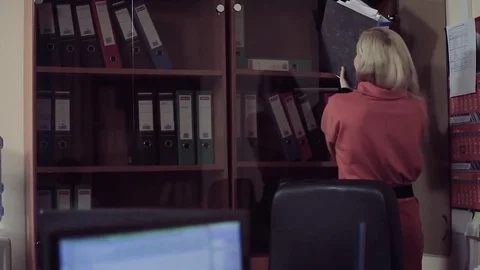 Two pretty office colleagues separating documents. Stock-Footage 77109732