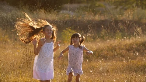 Two  pretty sisters, four and seven years old, playing with splashes of water 스톡 동영상 115007472