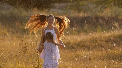 Two  pretty sisters, four and seven years old,  playing with  water splashes 스톡 동영상 115008599