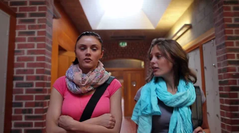 Two pretty students walking down hallway to locker Video stock 32881675