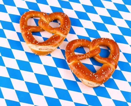 Two pretzel in heart shape on white blue background Stock Photos