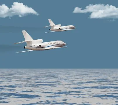 Two private jets flying over the ocean Stock Photos