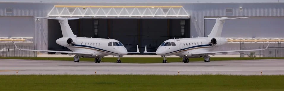 Two private planes in front of a hangar Stock Photos