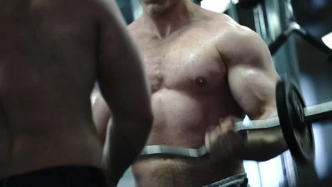 Two pro bodybuilders work together to sculpt impressive biceps Stock Footage 241168297