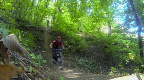 Two pro downhill cyclists passing by fast Stock Footage 55943767