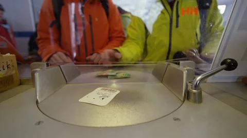 Two pro freeride skiers buying ski pass at the cashier, Switzerland Stock Footage 129088622