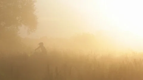 Two pro moto cross bikers racing on the hills agains the sun. Stock Footage 88437510