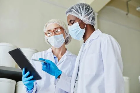 Two Process Technicians Using Tablet Taking Inventory of Products at 写真素材