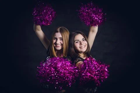 Two professional cheerleaders posing at studio on black screen Stock Photos