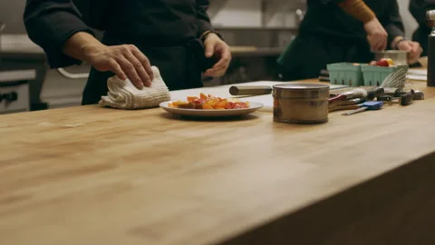 Two professional chefs talking and lifting a plate of tomatoes in industrial kit Stock Footage 199460633