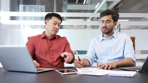 Two professional colleagues having a thoughtful discussion in modern office  Stock Footage 299569999