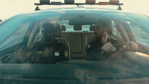 Two professional cops afro-american driving a high speed car patroling the city Stock Footage 112989502