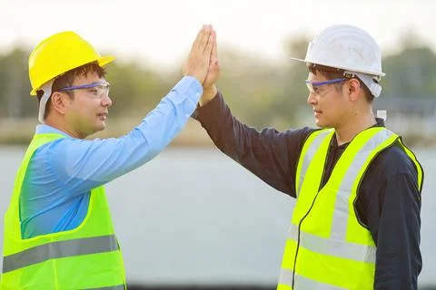Two professional engineers discussing and glad in success during working at.. Stock Photos
