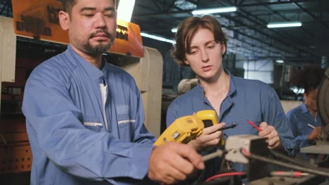 Two professional engineers inspect machines' electric systems at the factory. Stock-Footage 199173680